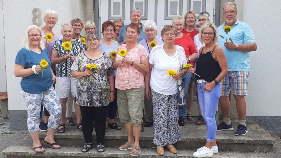 Das Foto zeigt die Sommerfest-Teilnehmenden, alle haben eine Sonnenblume in der Hand. | Foto: Caritas